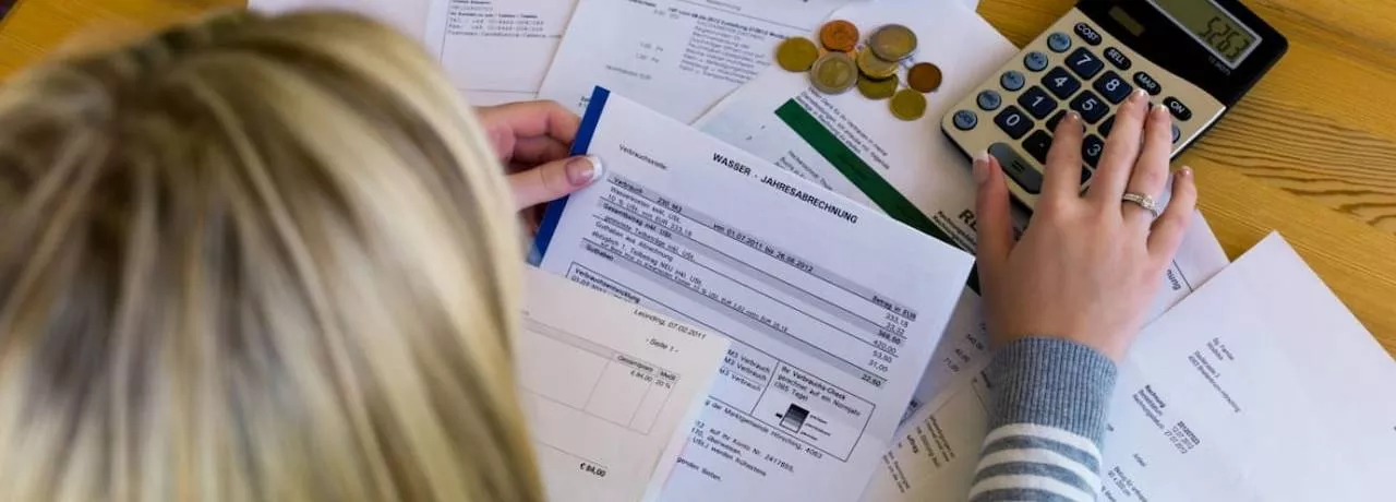 somaj tehnic durata, calcul - o femeie vazuta de sus muncind la calcule cu hartii si calculator - Pluxee 