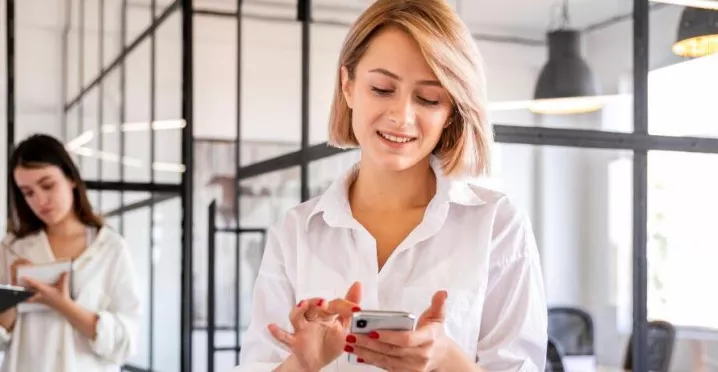 Ce funcționalități esențiale trebuie să aibă o platformă de beneficii flexibile în 2026? - angajata verificand telefon - pluxee.ro