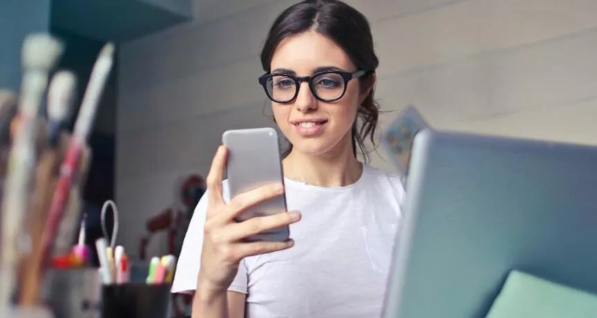 Generația Z motivare - femeie, telefon, laptop, birou - pluxee.ro