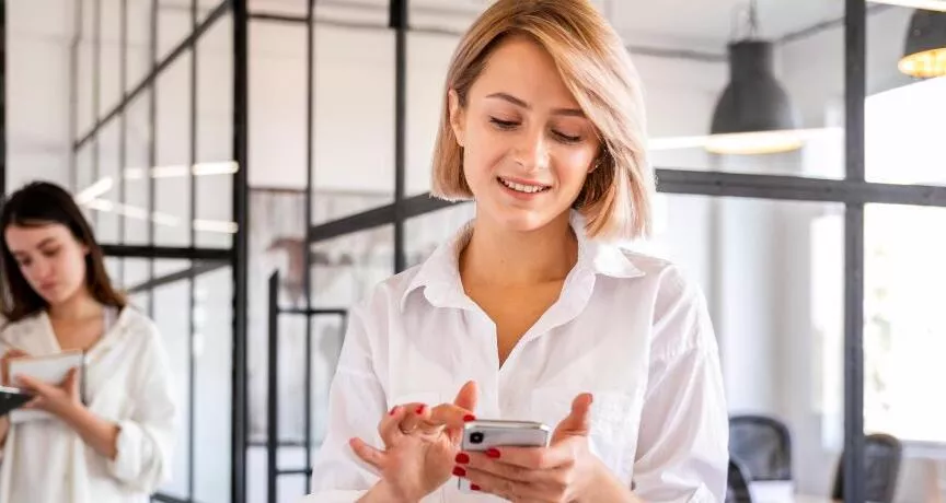 Ce funcționalități esențiale trebuie să aibă o platformă de beneficii flexibile în 2026? - angajata verificand telefon - pluxee.ro