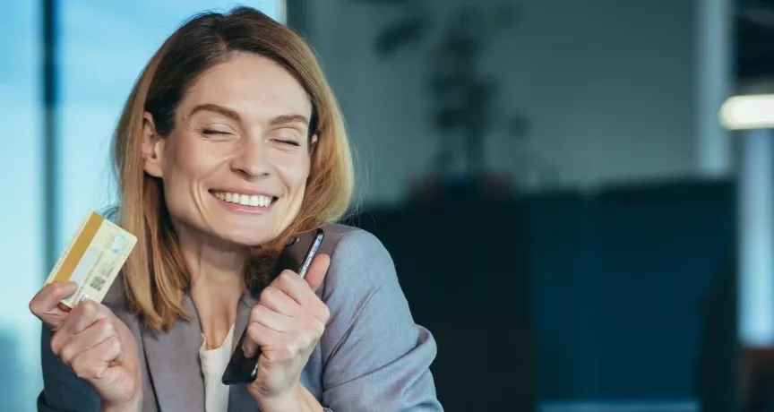 Cum pot optimiza costurile cu tichetele de masă ca IMM - angajata fericita la birou - pluxee.ro