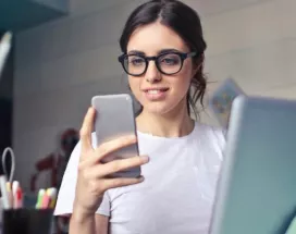 Generația Z motivare - femeie, telefon, laptop, birou - pluxee.ro