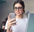 Generația Z motivare - femeie, telefon, laptop, birou - pluxee.ro
