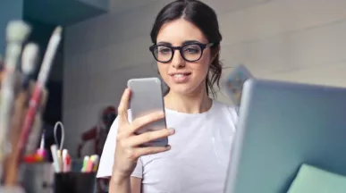 Generația Z motivare - femeie, telefon, laptop, birou - pluxee.ro