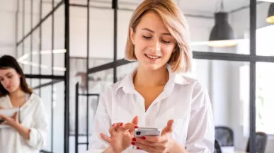 Ce funcționalități esențiale trebuie să aibă o platformă de beneficii flexibile în 2026? - angajata verificand telefon - pluxee.ro